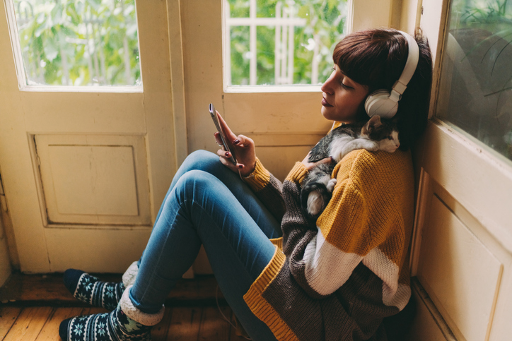 woman sitting on the floor wearing headphones.