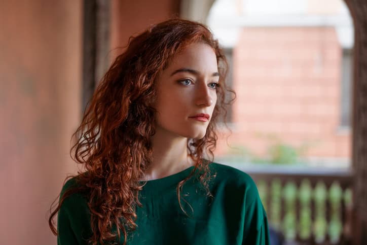 Woman standing alone feeling unsure.
