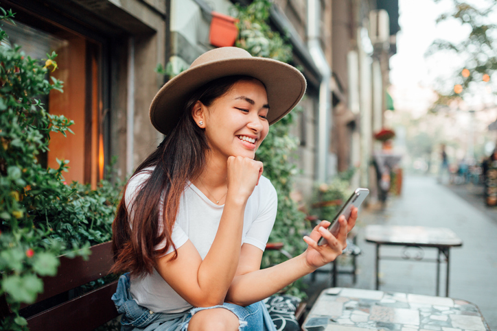 asian lady in hat using mobile