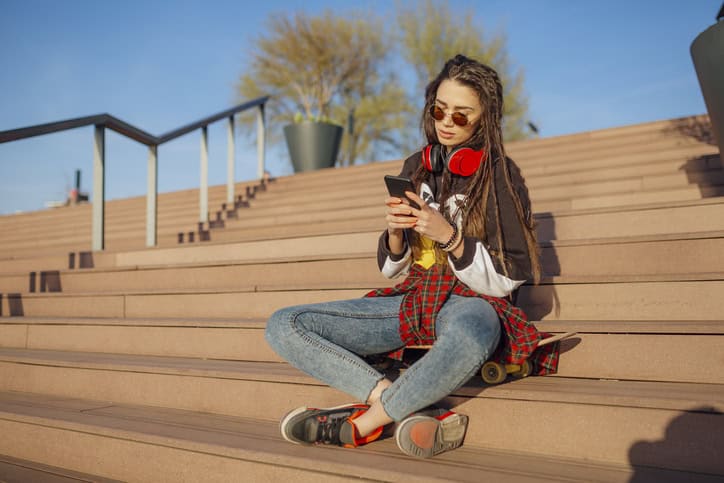 woman texting outside on steps