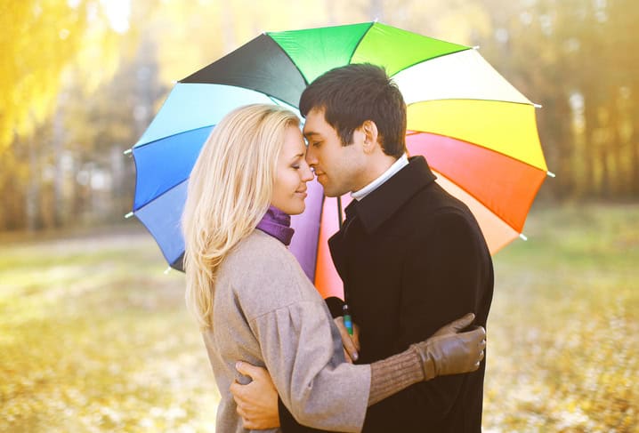 couple being romantic under an umbrella