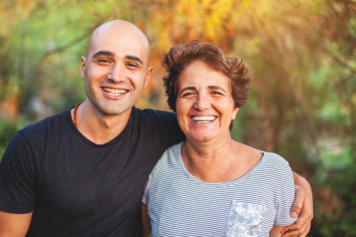 Mature mother and young son smiling at the park.