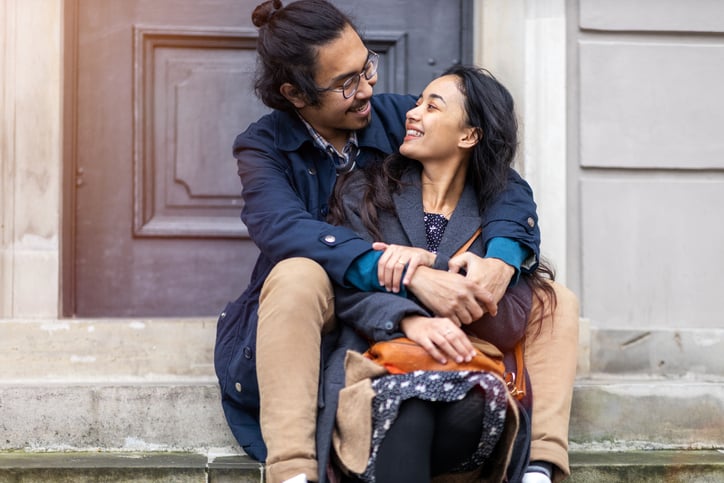 happy young couple sitting on some steps