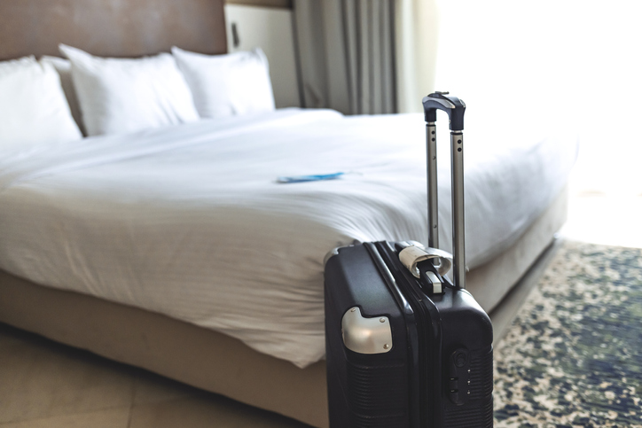 Black suitcase in a hotel room.