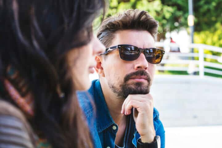 man with glasses arguing with woman