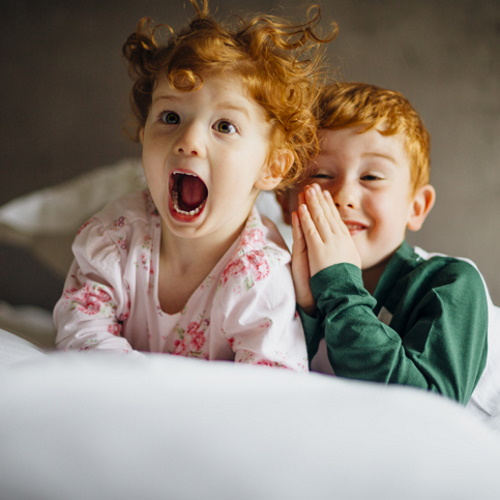 Two young children laughing together.