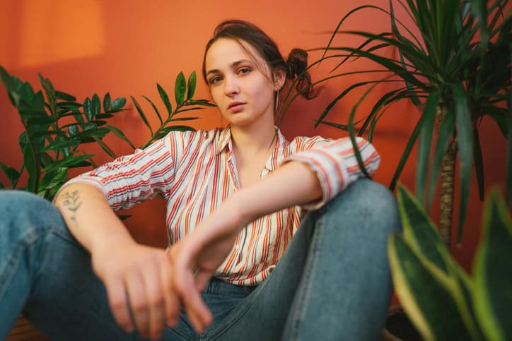 Woman with a wall of plants.