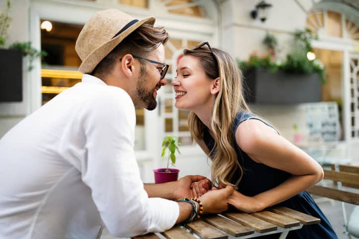 couple nose to nose about to kiss over a table