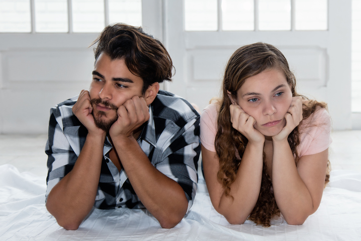 Unhappy couple on the bed.