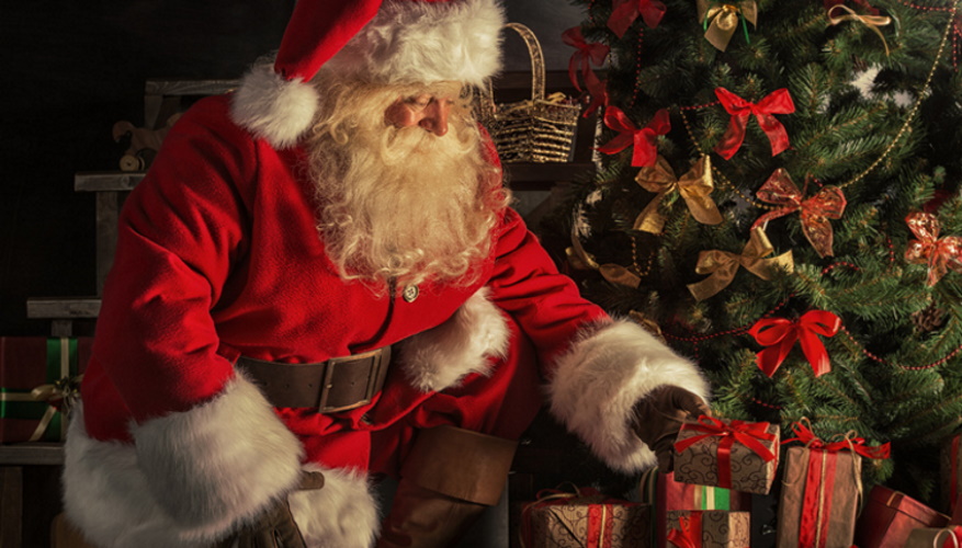 Canta Claus leaving gifts under the Christmas tree. 