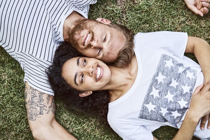 two people laying on the ground smiling