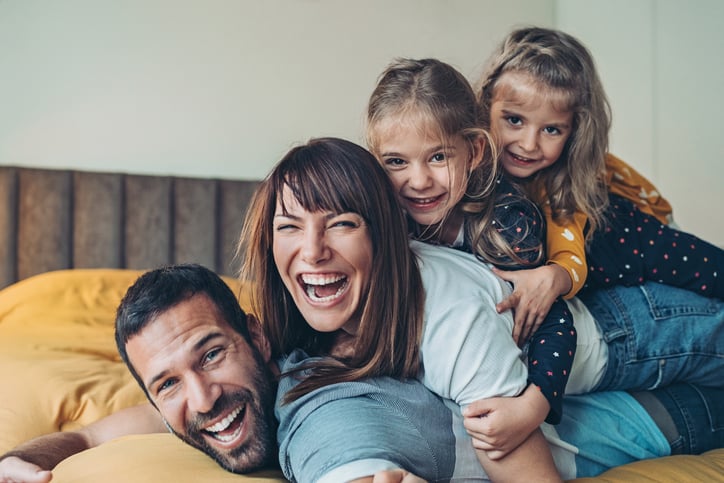 Two parents smiling with their two children.
