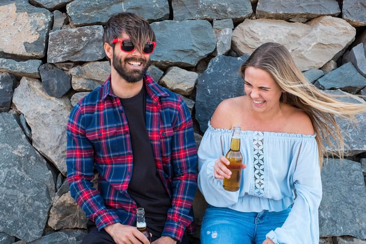 couple laughing against wall