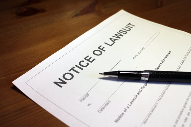 A lawsuit notice and a pen.