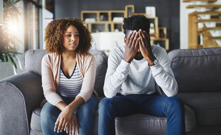 Unhappy couple sitting on the couch.