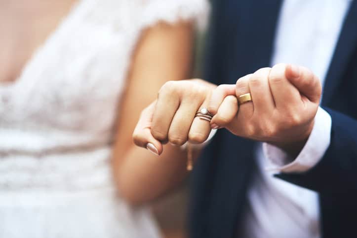 A bride and groom with their wedding rings.