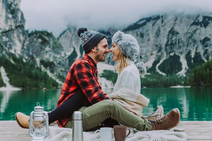 couple sitting in the mountains kissing