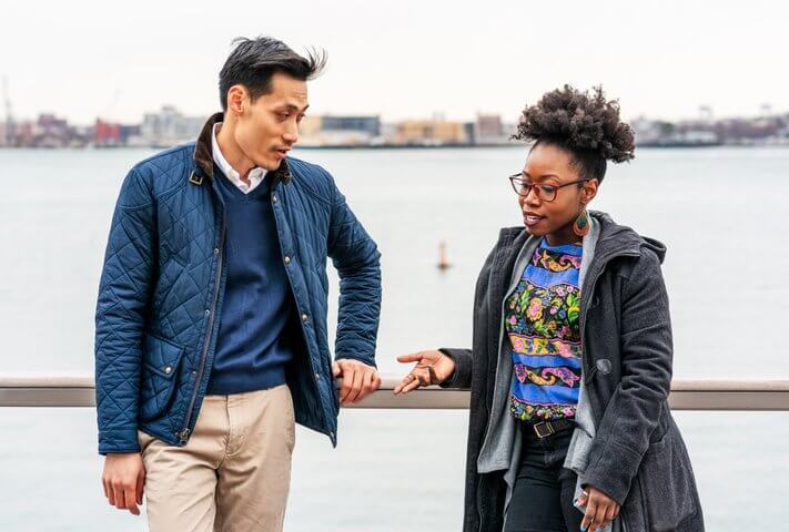 A man and woman chatting in Boston's harbor area.