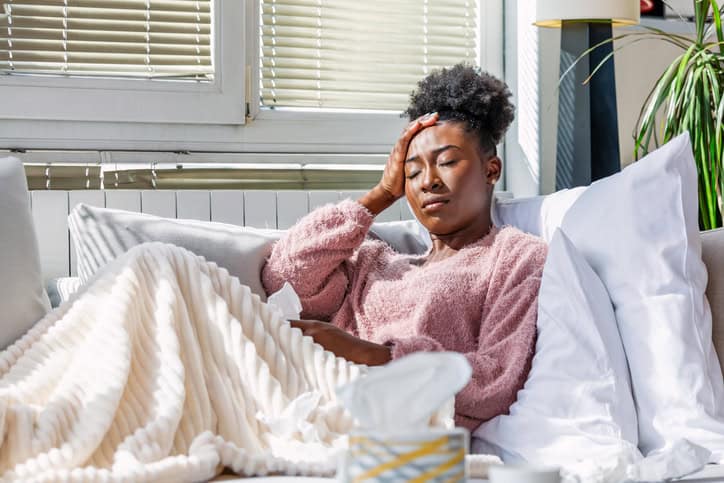 african american woman laying at home sad