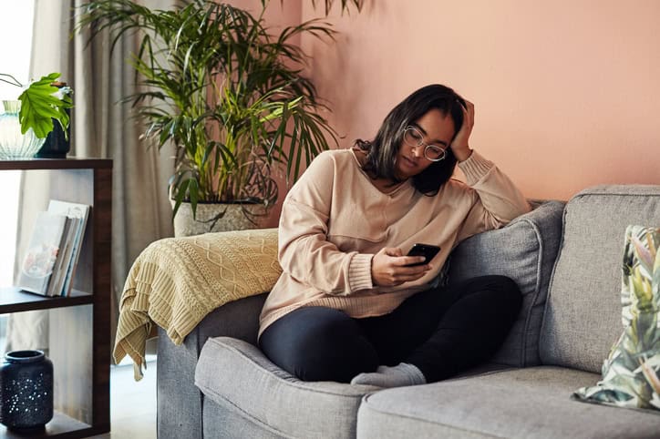 asian woman sitting sofa texting