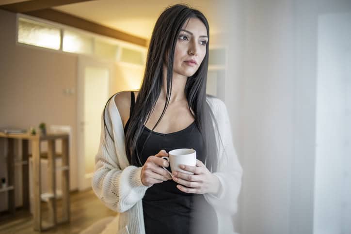 long haired brunette holding a cup