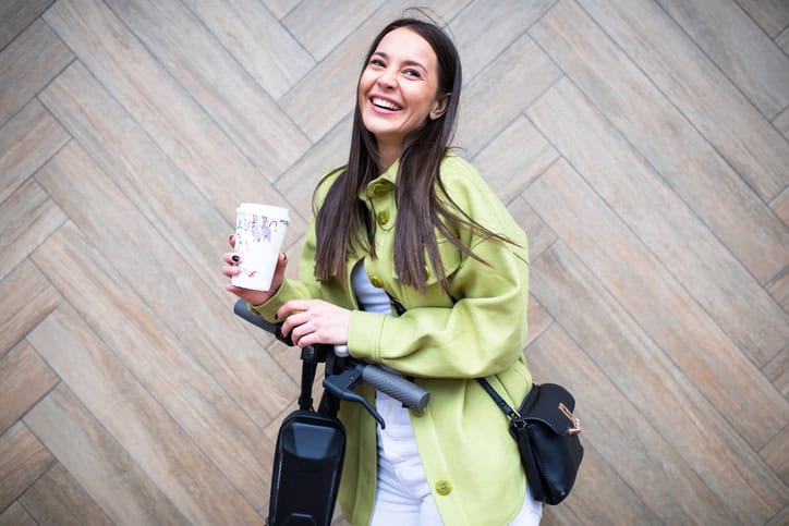 woman in green coat riding a scooter