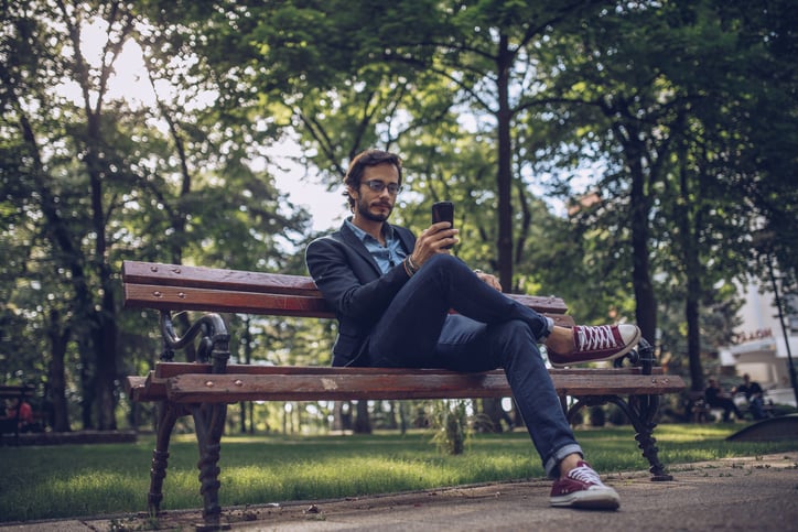 man outside park texting