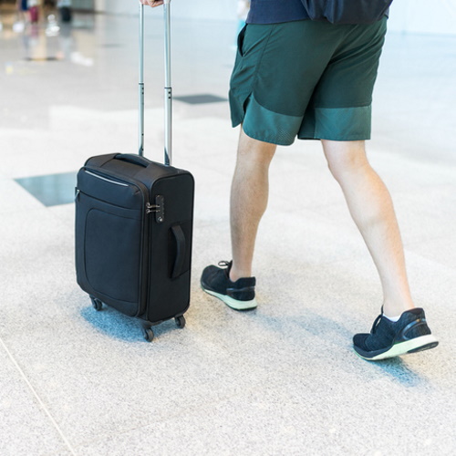 Man rolling his suitcase.