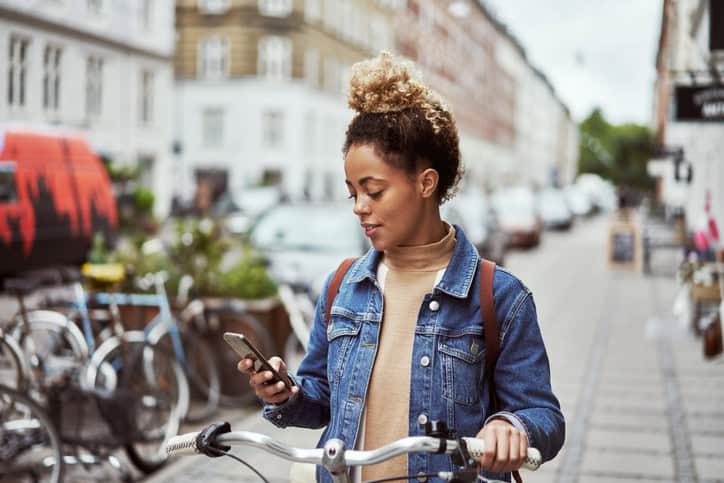 black woman texting on bike