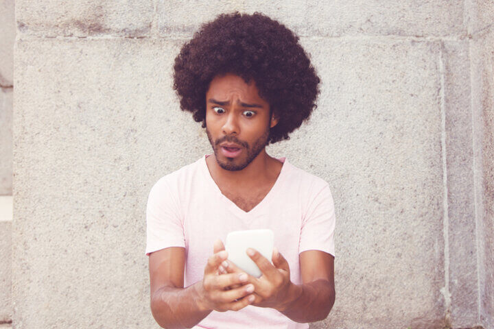 afro american man texting shocked