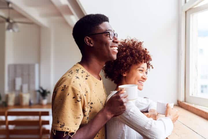 african couple smiling at window
