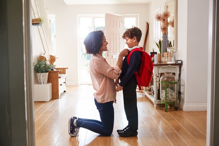 mother dressing son for school