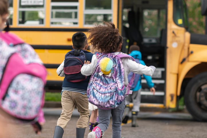 Children getting on a school bus.