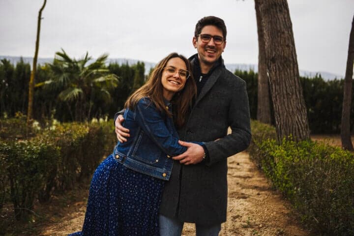 couple embracing by christmas trees outside