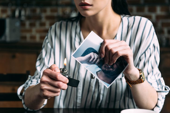 Woman burning photo of her ex-boyfriend.