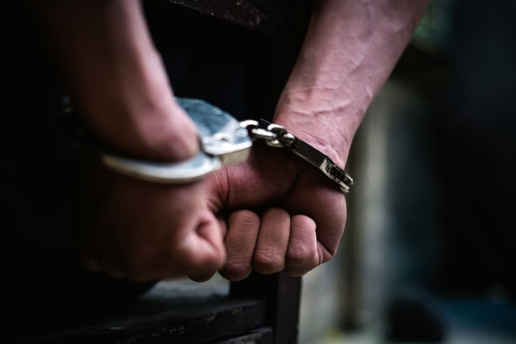 Man wearing handcuffs behind his back.