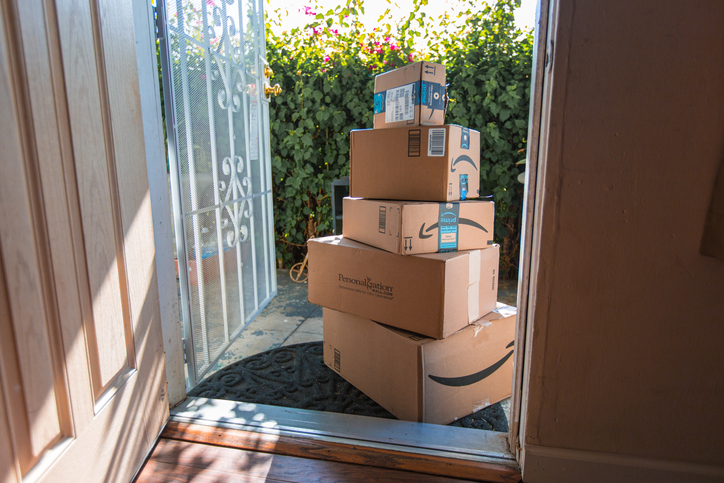 A stack of Amazon packages at the door.