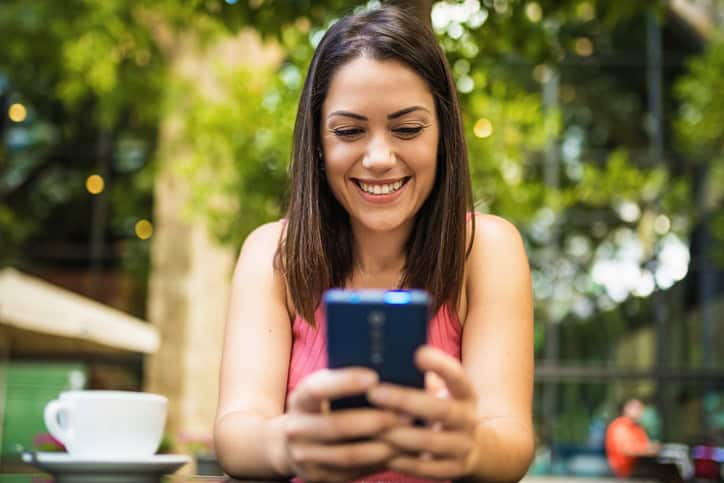 smiling brunette woman texting