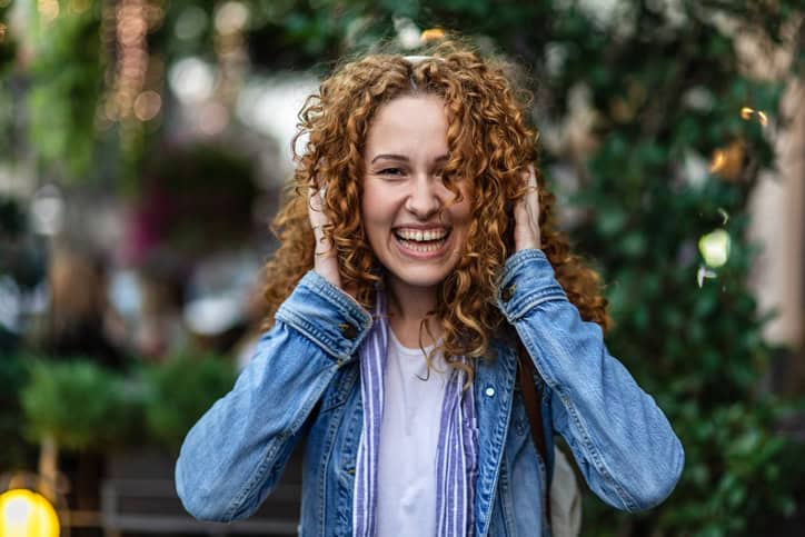 curly haired woman listening to music