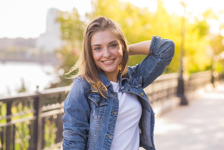 young woman smiling holding arm up