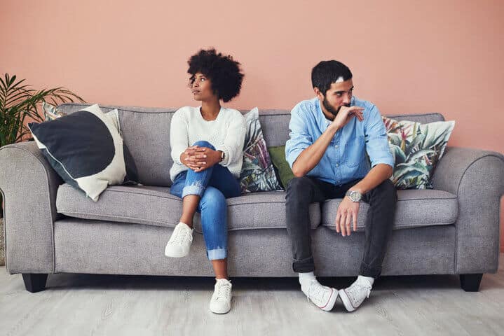 unhappy couple sitting on couch