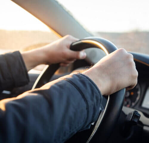 man driving car hands shot only
