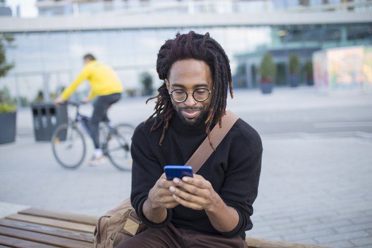 Black man texting city center