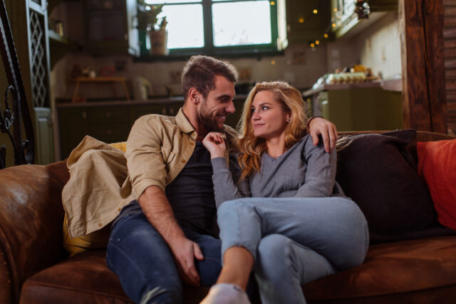 romantic couple cuddling on couch