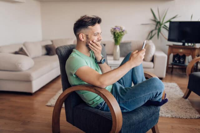 guy on smartphone in living room