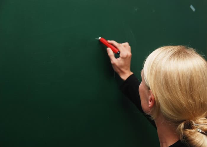 Female teacher writing on the blackboard.
