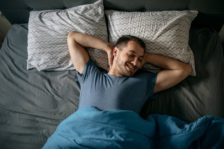 man happy laid in bed