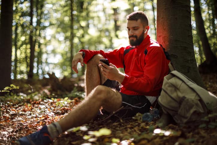 Young smiling man alone in the forest.