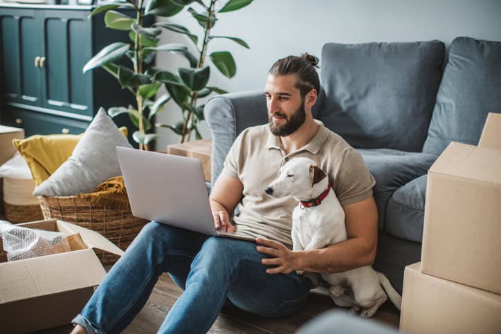 man with his dog on laptop
