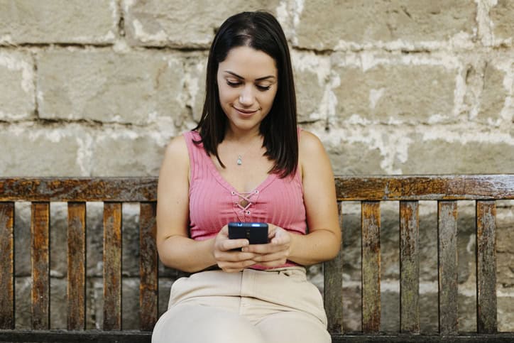 woman using smartphone on bench